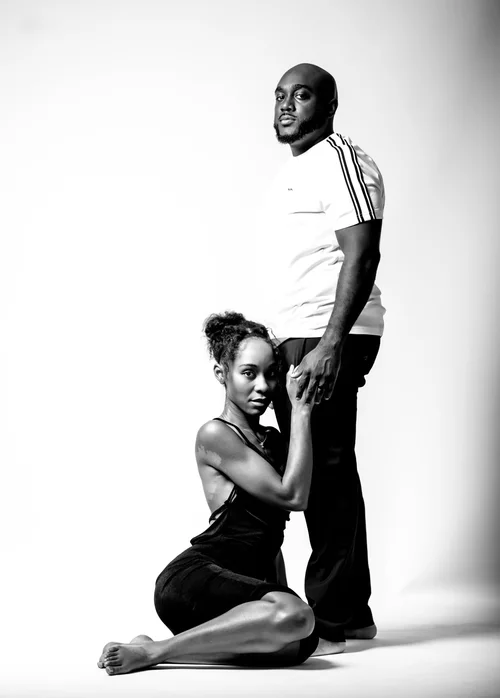 Black and white couple in the studio, she seated at his feet