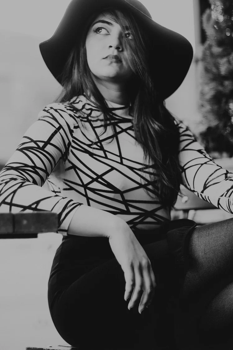 Black and white portrait in a wide-brim hat and patterned top