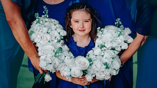 Flower girl framed by white rose bouquets