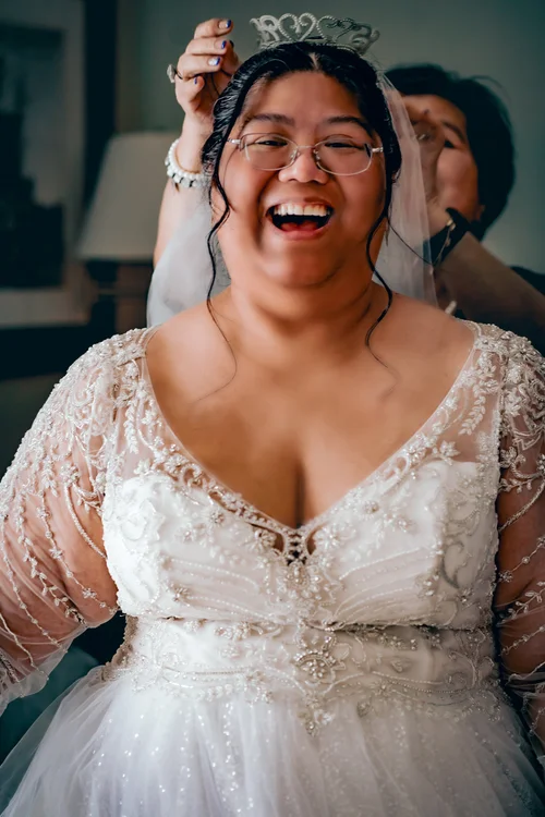 Bride laughing as her tiara is set in place