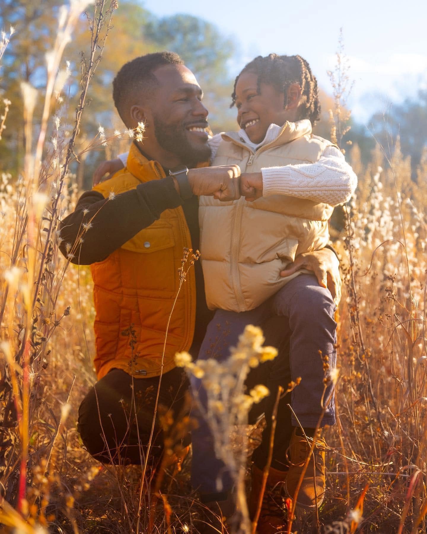 Father and son bumping fists in a golden meadow
