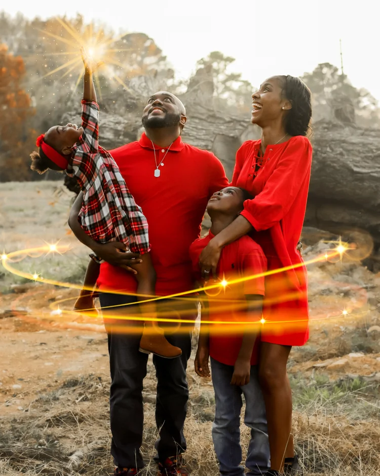 Family in red looking up as a ribbon of golden light circles them