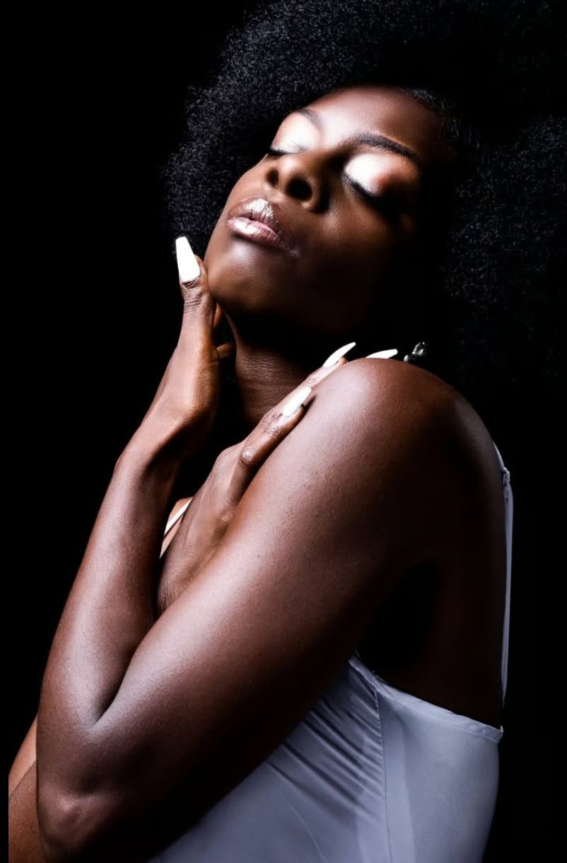 Woman with eyes closed, sculpted by low light on black — Editorial lifestyle portrait by Claudia Quiana