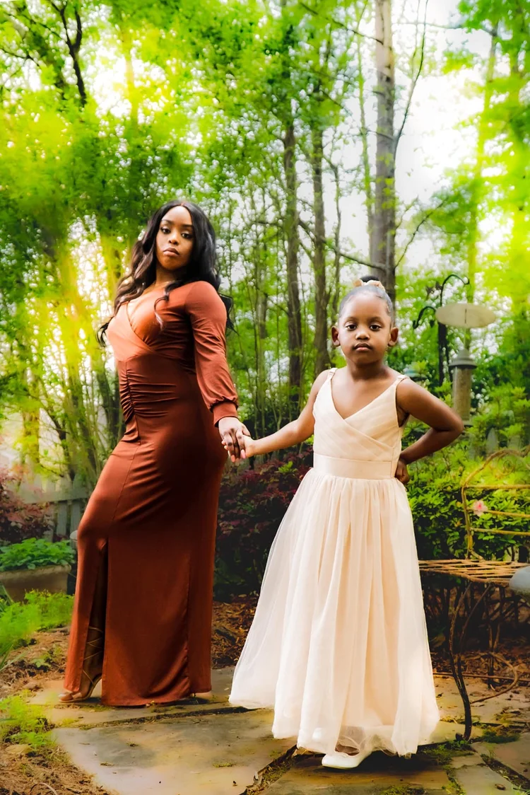 Mother and daughter holding hands in a sunlit forest