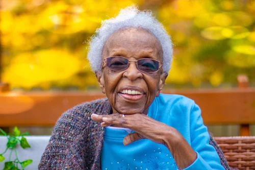 Smiling grandmother in a blue sweater against autumn gold