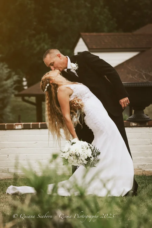 Groom dipping his bride into a kiss on the lawn — Intimate wedding photography by Claudia Quiana