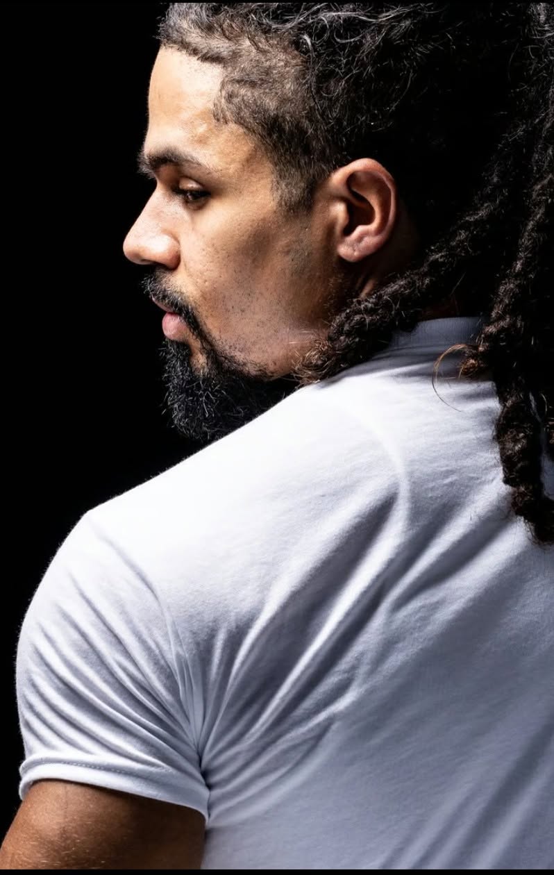 Profile of a man with locs in a white tee on black — Editorial lifestyle portrait by Claudia Quiana