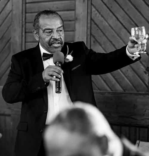 Black and white toast with a raised glass and microphone
